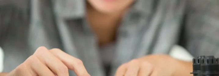 Person schneidet Schlauch mit einem Cuttermesser.